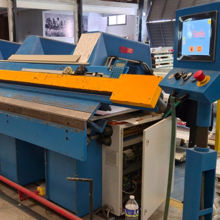 Máquina industrial de plegado con un panel de control digital y un agarre amarillo.