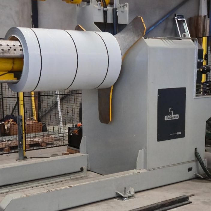 Máquina industrial con rodillos y estructura metálica en un entorno de fábrica.
